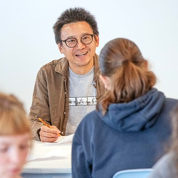 Photo of Pulitzer Prize-winning author Hua Hsu speaking at a podium.